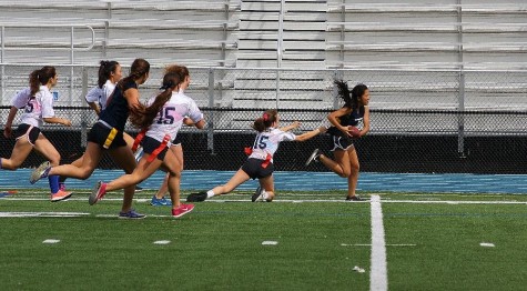 Sophomore Annabelle Lee dodges defenders as she streaks toward the end zone in the seniors versus sophomores Powderpuff game.