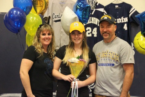Senior Jacey Phipps smiles with her parents as they all wear San Jose State University apparel.