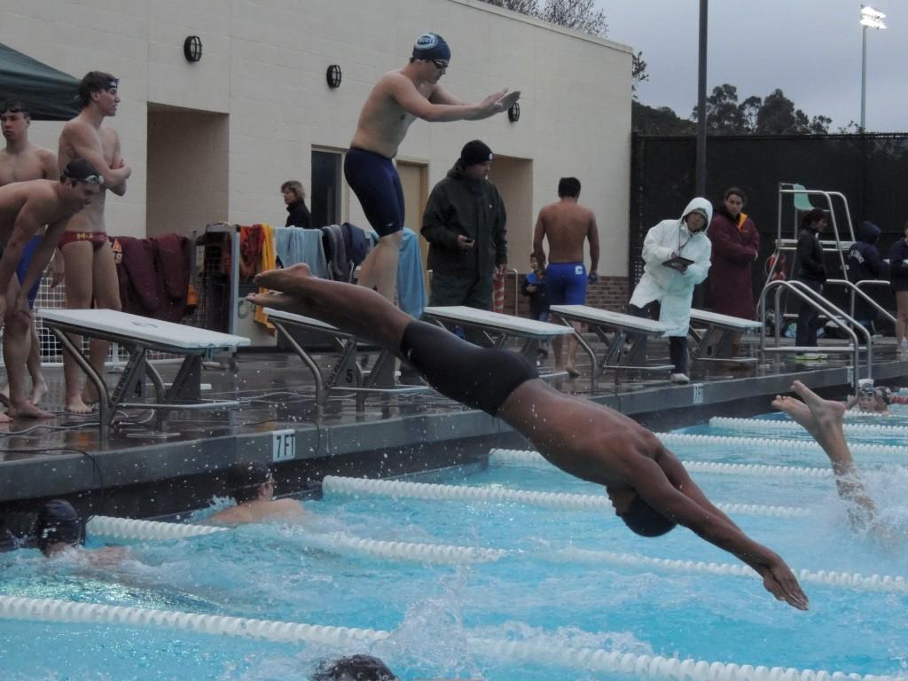 Varsity swimmer Nico Camerino dives into the pool at the beginning of the 100 freestyle relay.
