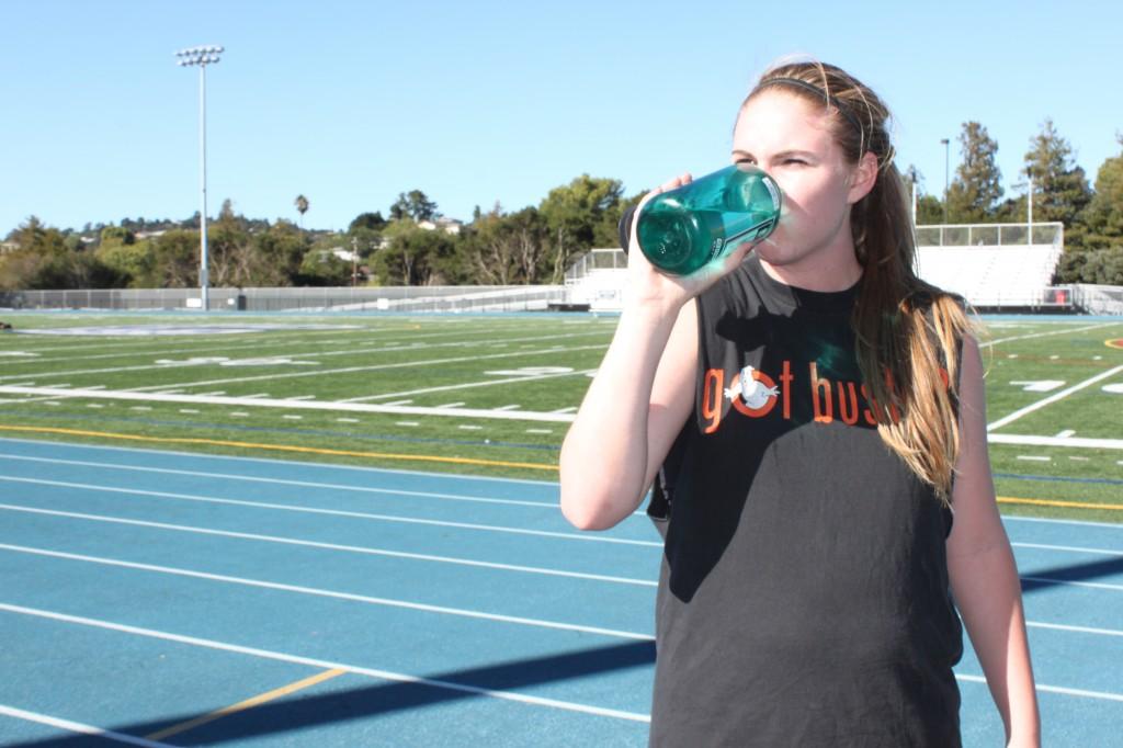 Girls varsity basketball player Erin Lucett rehydrates after running a lap for conditioning.
