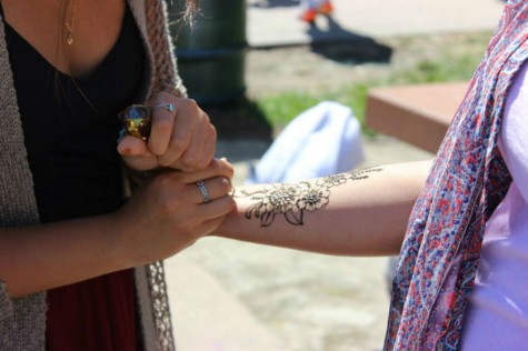 Senior Emma Lin adds the finishing touches to a students henna tattoo at the Club Fair.
