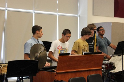 Percussionists in Concert Band work together while playing through a piece.