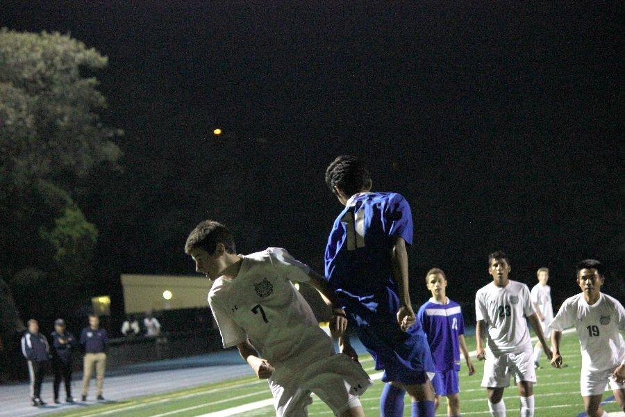While playing striker, sophomore Leo McBride leaps into the air and beats his opponent to the ball as he heads it away from pressure.
