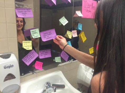 Erica Aldanese looking at the sticky notes in the U-hall bathroom
