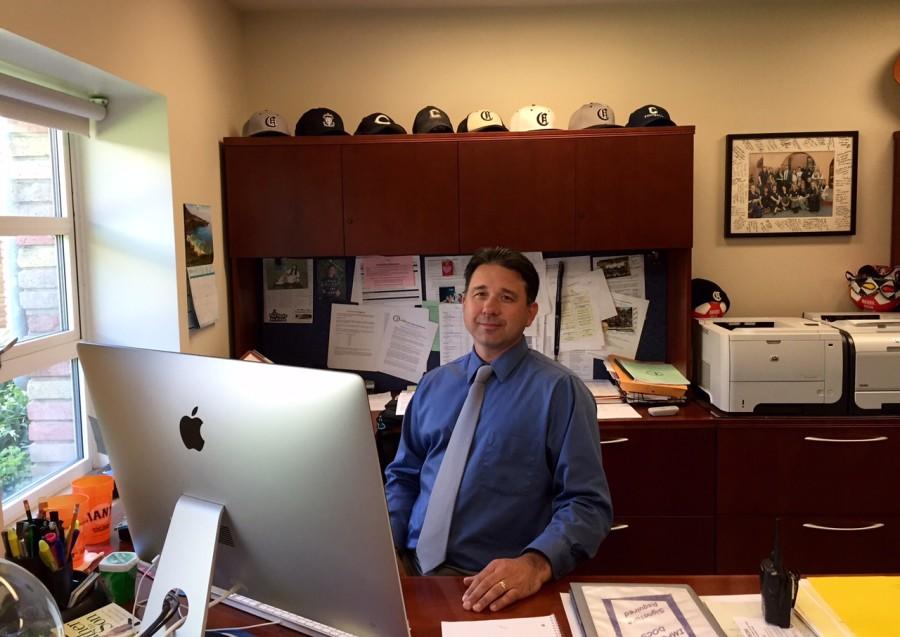 Crame sits in his office, where he works to make sure that the school runs smoothly.