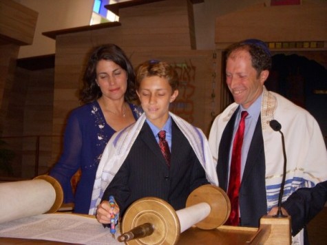 Former Carlmont student Josh Fagel stands with his parents as he reads the Torah, the central text of Judaism.