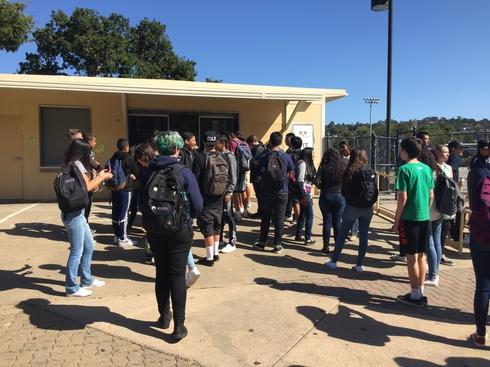 A crowd of students gathers to buy lunch right after the bell rings.