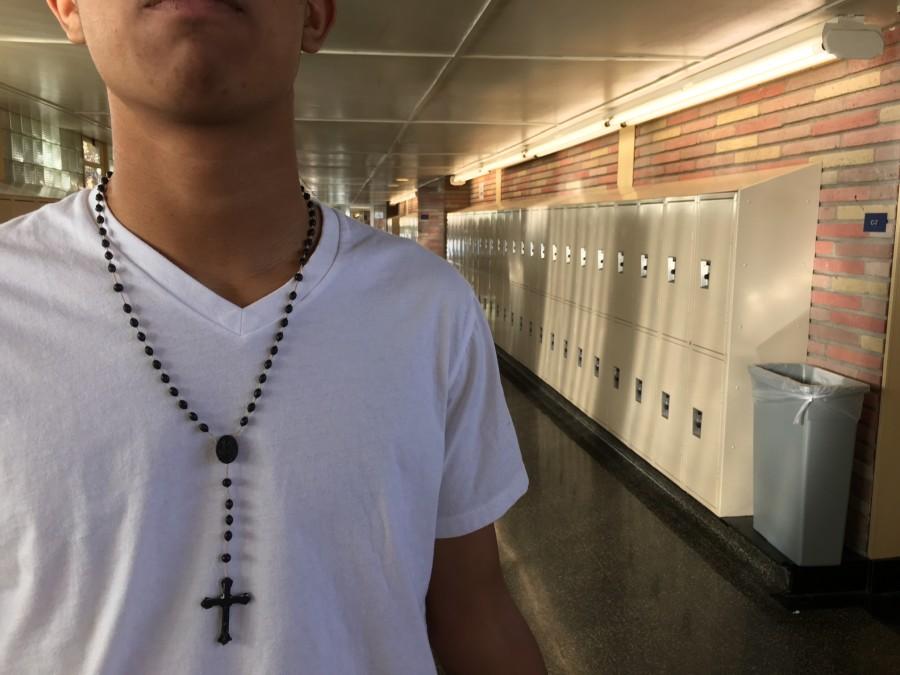 Wearing his cross on his neck, sophomore Josef Gonzalez walks down the halls of Carlmont.