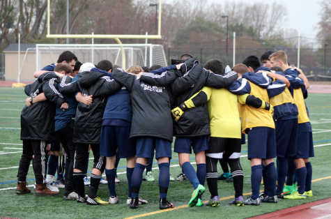 The players and coaches put their arms around each other during a pre-game pep talk.