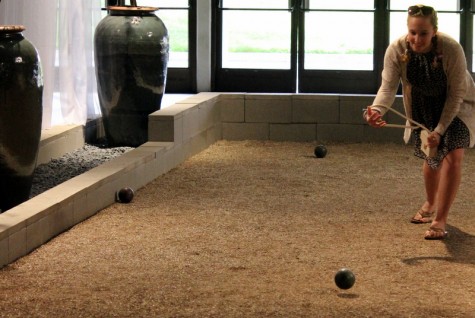 A visitor plays on the bocce ball court within an indoor garden display. 