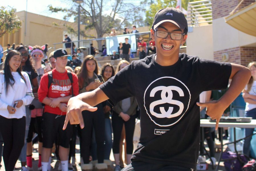 Students gather around the quad while junior Miguel Encarnacion dances to the music.