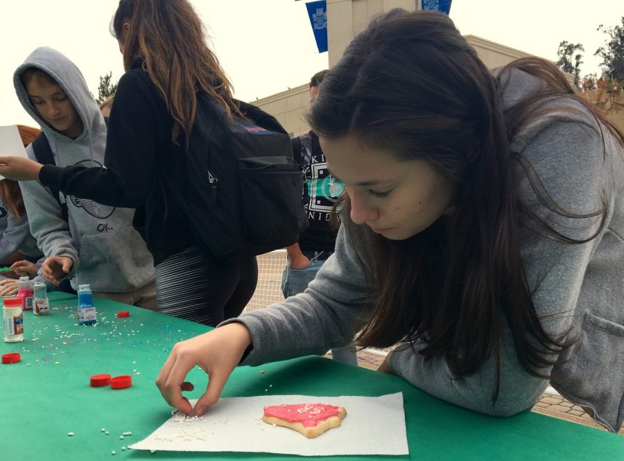Jade Sebti, a junior, decorates a holiday cookie as a gift to a friend.