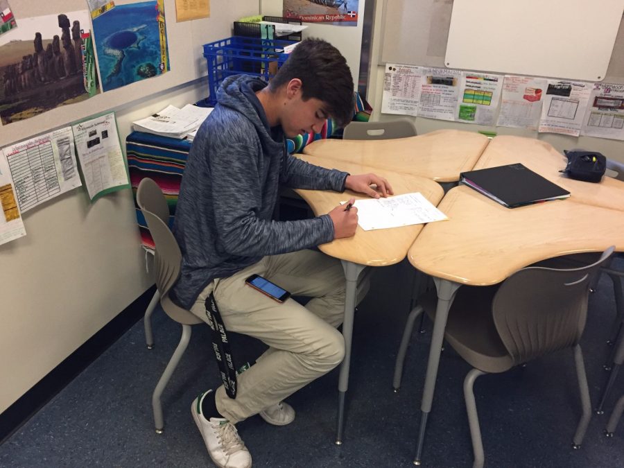 A student uses his phone under the test to get a better grade on his test.