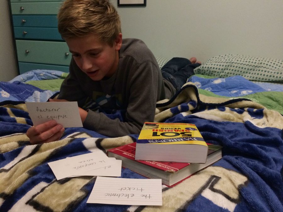 Freshman Aidan Truel studies a deck of flashcards with Spanish vocabulary about airports. 