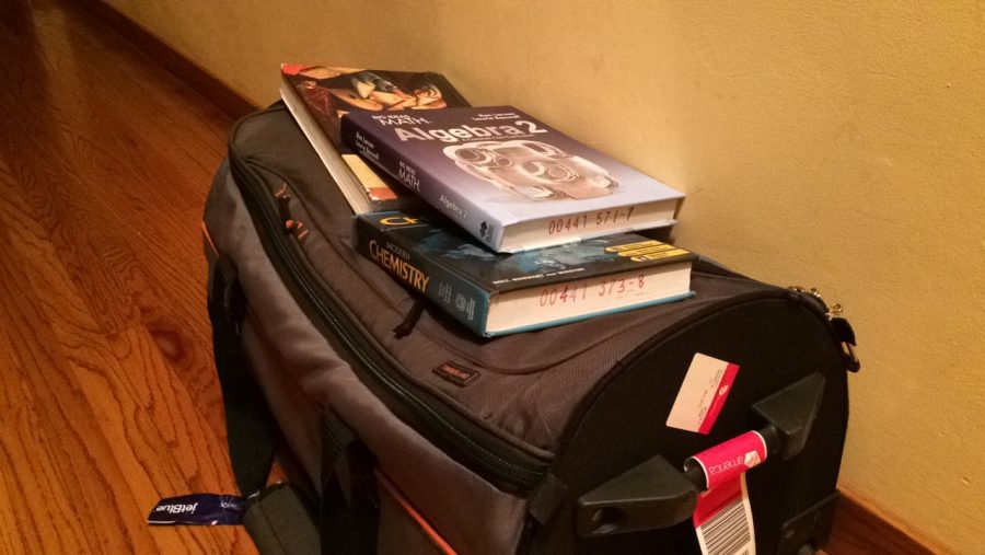 Baggage and textbooks waiting to be taken to the airport for a semester abroad. 