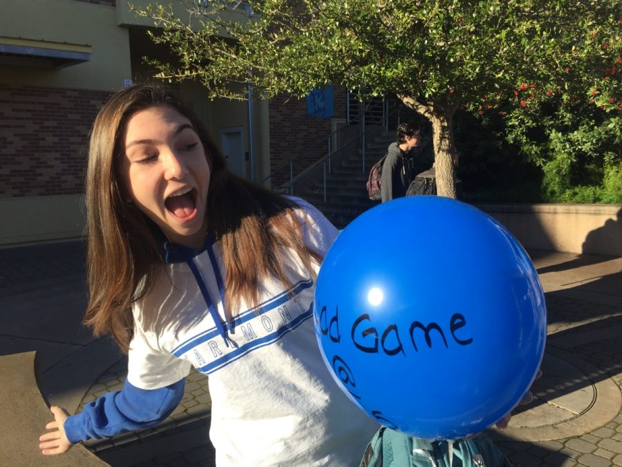 Sophomore Olive Peschel, wearing blue and white to represent Carlmont for the Scots day, plays with a balloon during passing period. The blue balloon advertises the quad game taking place that night.
