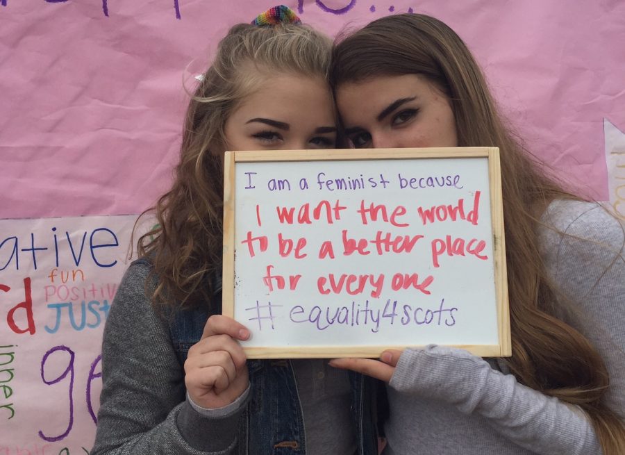 Sophomores Kaylee Moropoulos and Izzy Bruguera pose with their whiteboard message at an activity during 2016 gender equality week. 