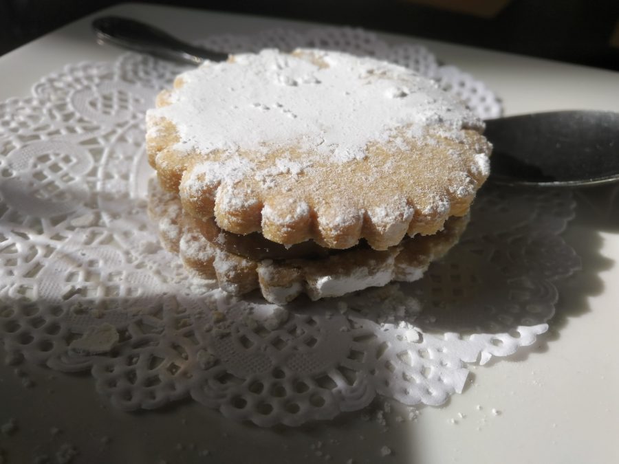 An alfajore has a crumbly, sugar-coated top which conceals a delicious dulce de leche-filled interior.