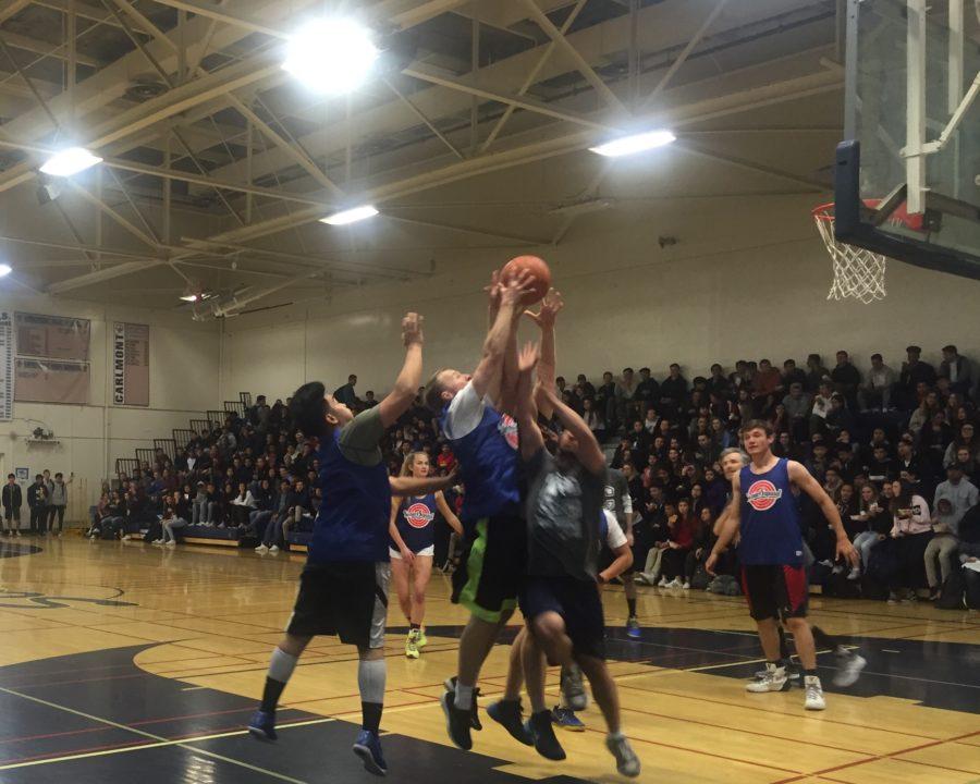 Staff and students fight to score in the senior vs. staff basketball game on March 24 in the main gym. 