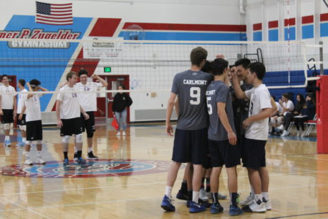 Carlmonts starting six form huddle to motivate themselves and focus on the game. Carlmont beat Hillsdale High School in three sets on March 20.