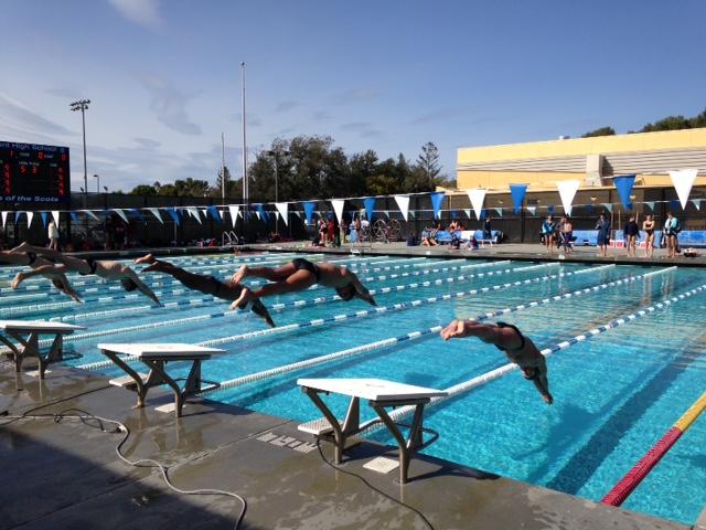 Carlmont and Woodside swimmers dive off the blocks to begin the heat.