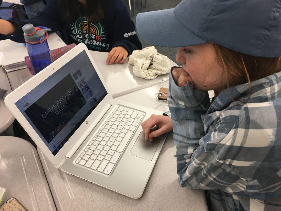 Elyse Geimer, a senior, watches a recent video about the upcoming event Carlmonts Got Talent on a computer after school.