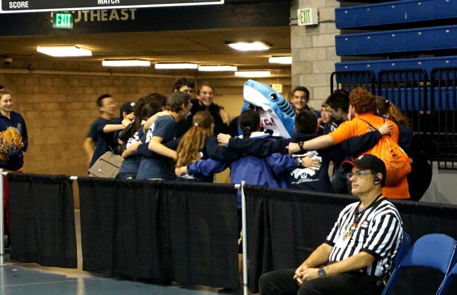 Deep Blue celebrates the results of their win at Sacramento Regionals with a group hug, including the teams mascot.