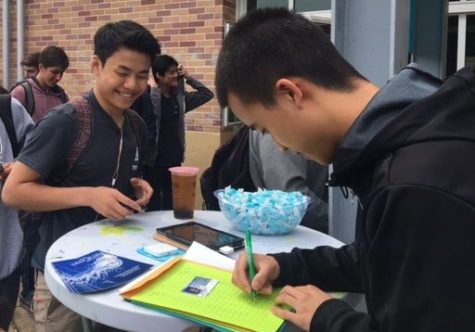 Justin Wang, a junior and the finance commission supervisor, helps fellow junior Alec Tung buy his prom ticket.
