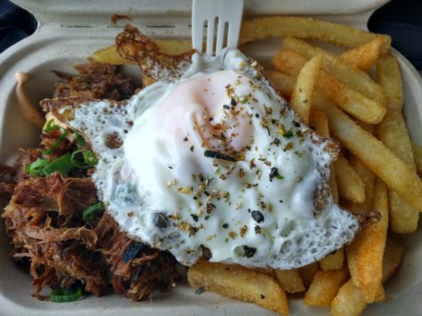 A meal consisting of spiced  pulled pork, a fried egg, white rice, and french fries  tastes really good.