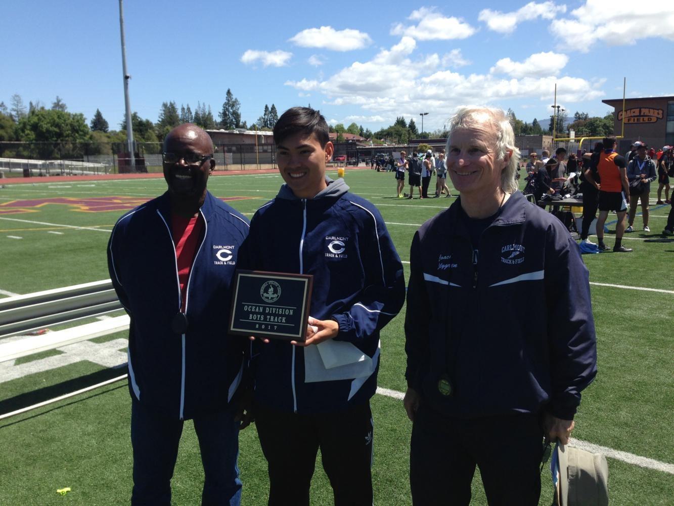 Coaches James Jewett (left), John Gray (center), and John Lilygren smile after being given the plaque for Boys Track and Field Ocean Division winner. Carlmont will move up to the Bay Division next year because of this win.