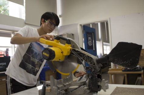 Freshman Andrew Shao uses a large cutting tool in the shop.