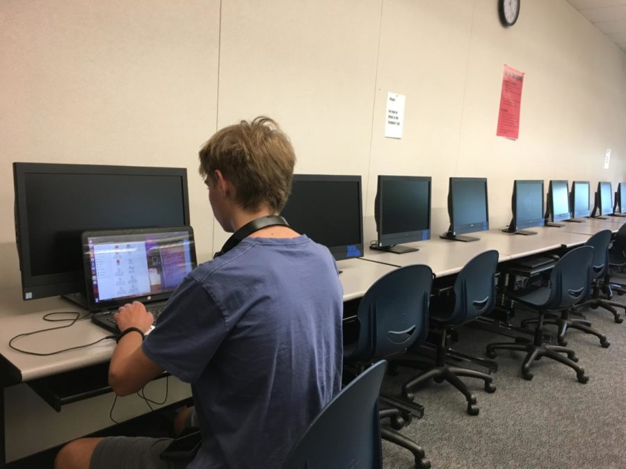 One of the club members stays in the classroom after lunch to finish their current computer science exercise.