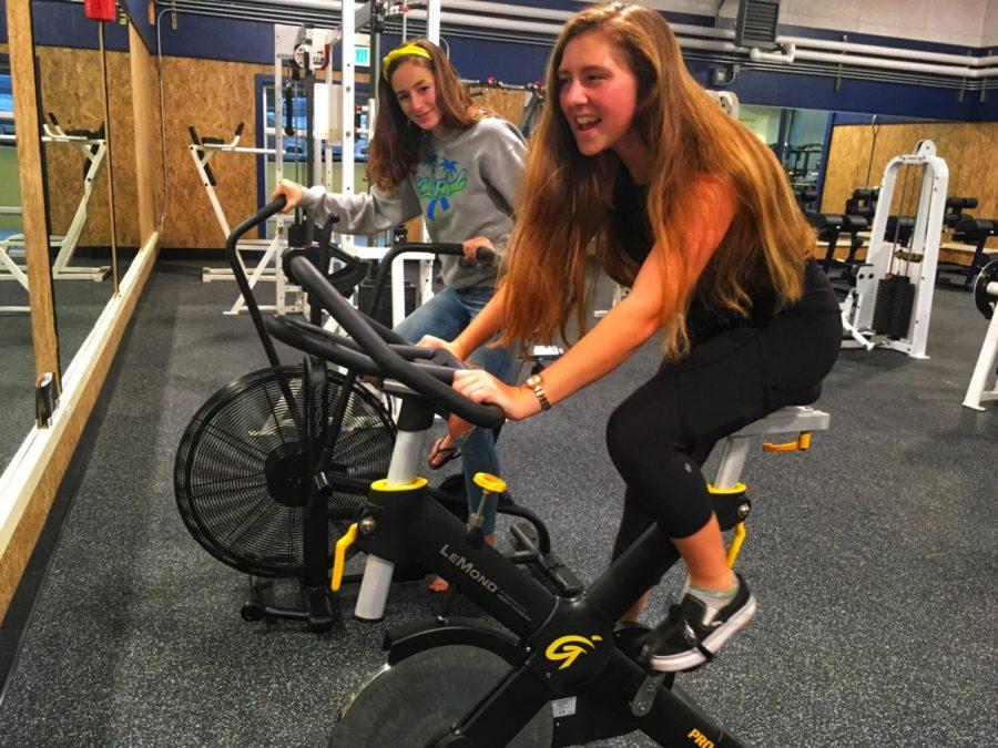 Freshmen Nyah Dompier-Norrbom and Mia Messina test out the new spin bikes. The new weight room is really nice. It looks like a college weight room, said Messina.
