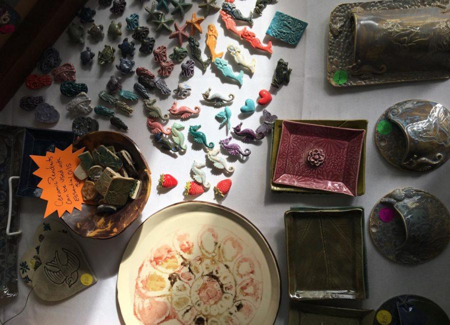 Ceramic pins are displayed on a table at the art festival.