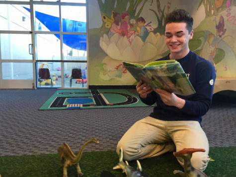 Ryan Huskey, a junior, reads to toddlers as a part of his job as a Childcare Associate at the Bay Club in Redwood Shores. I love my job because it better prepares me to become a parent in the future, said Huskey.