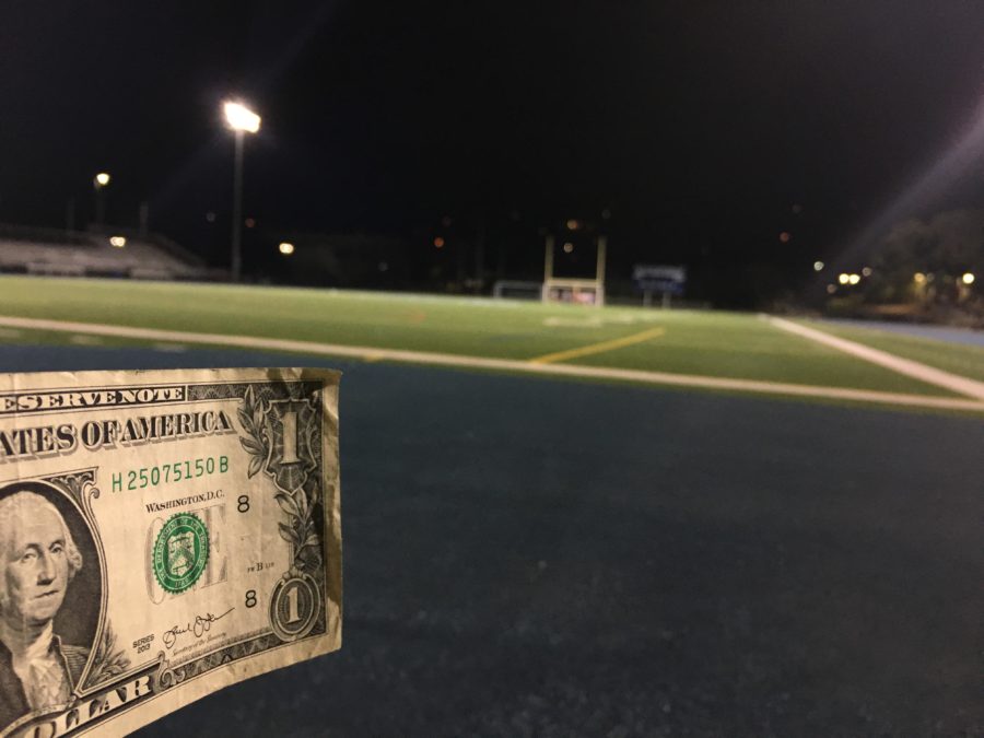 A dollar bill displayed in front of the Carlmont football field.
