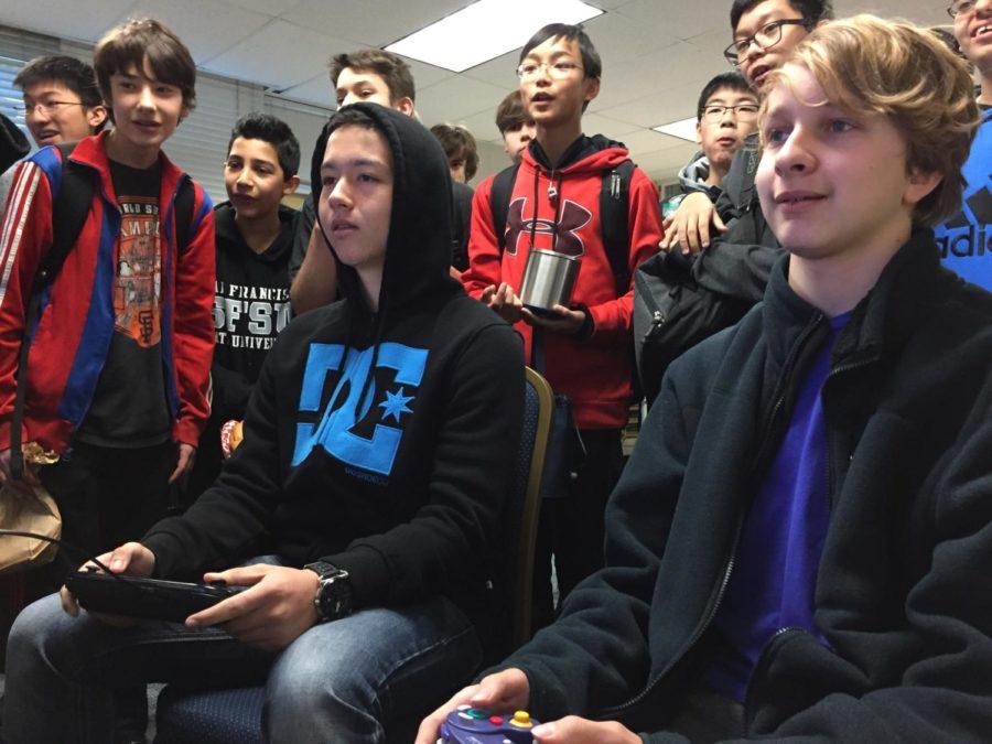Students watch as two competitors face off in a Super Smash Bros. battle. 
