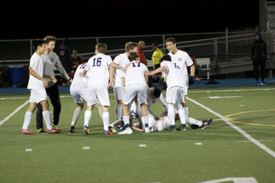 The Carlmont team celebrates on the field after a goal.