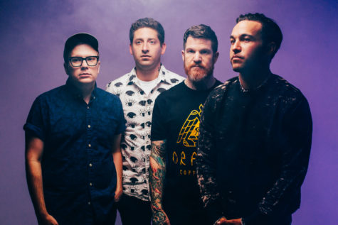Members of Fall Out Boy (Patrick Stump, Joe Trohman, Andy Hurley, Pete Wentz) promote their new album, M A N I A, with the album covers electronic purple background.