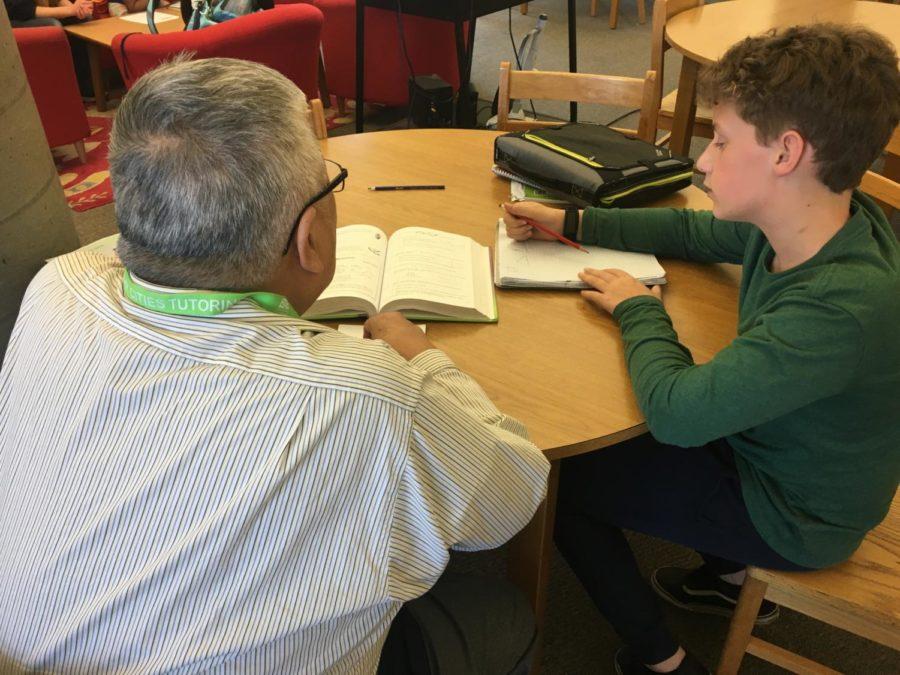 Healthy Cities tutor Kelvin Lee helps eighth grader Charlie Baker with his homework at the Tierra Linda Middle School Library