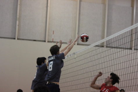Junior Max Jung and Jimmy Rudger, a senior, go up to block an Aragon players hit.