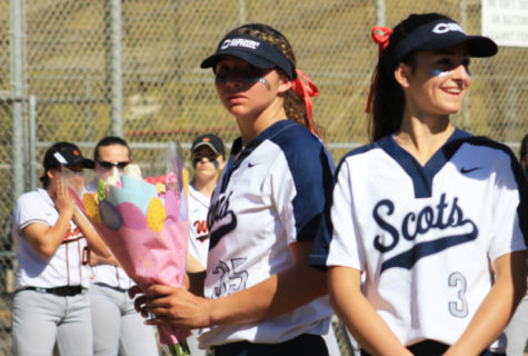 Senior captain and pitcher for the varsity team, Mailey McLemore, holds a bouquet of flowers for Jim Liggetts wife, Charlene Liggett.