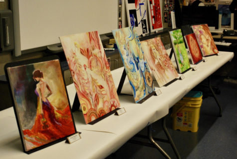 Oil paintings from the Studio Art class are displayed on tables along the front of F22 during Open House.