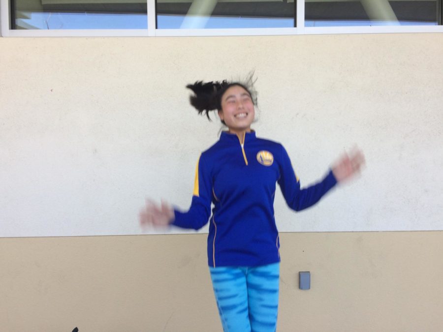 Annika Lin jumps for joy as she shows support for her favorite basketball team, the Warriors, for sports day on Tuesday.