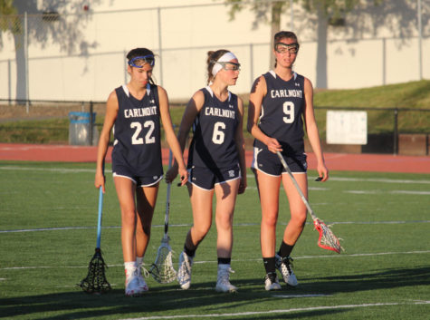 Freshman Sophie Brack (left), sophomore Caroline Conway (center), and senior Nicole del Cardayre walk towards their team after a loss to Woodside.