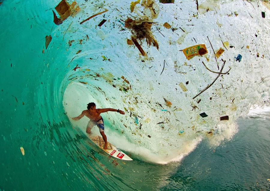 Surf champion, Dede Suryana, rides a wave filled with trash in Indonesia.