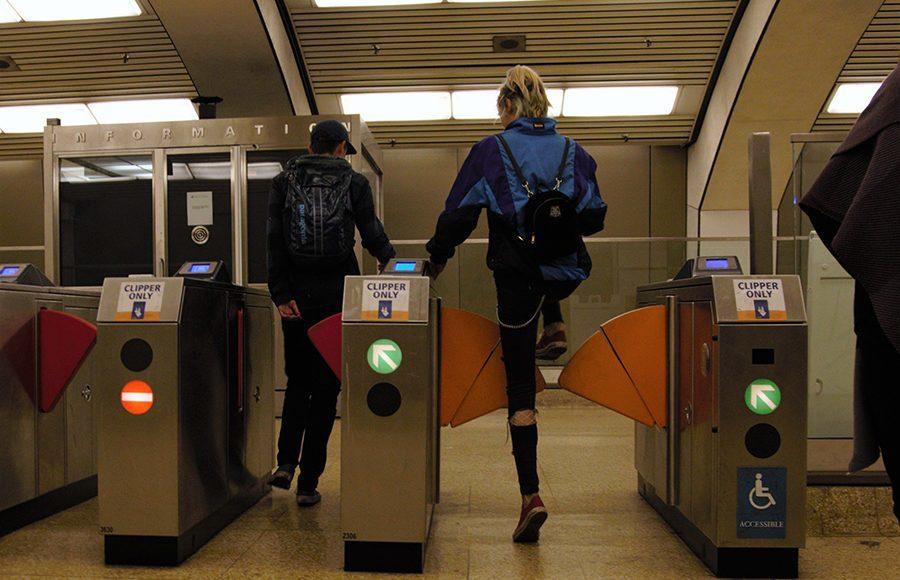 BART riders place their tickets through the ticket machine as they walk through the barriers. 