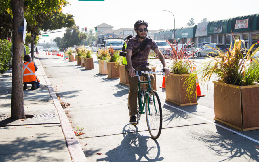 A bikers uses the new protected bike lane on El Camino Real during the test run on Oct. 20.