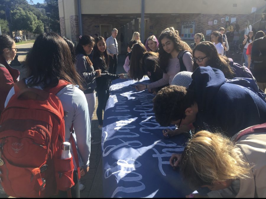 Students sign a poster to show their support against anti-Semitism. 