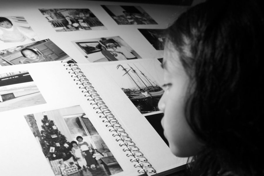  An adopted child looks at photos of her unknown biological bloodline. 